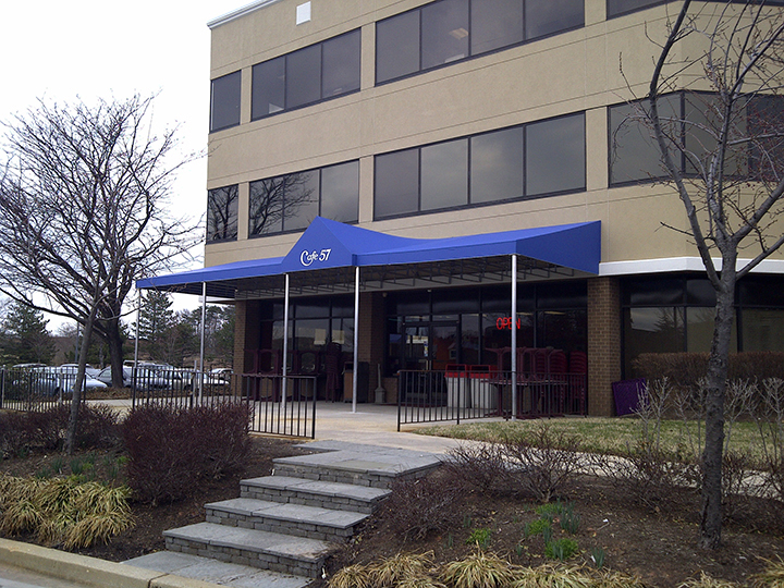 office building with large blue canopy that says Cafe 57